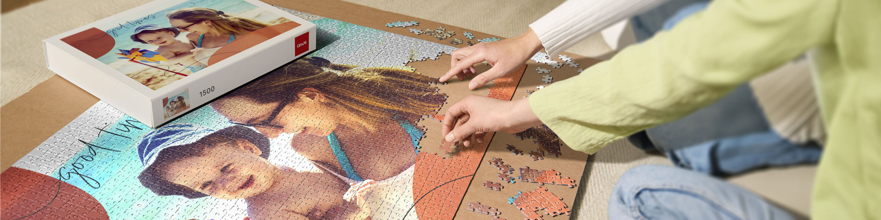 Eine Mutter und ihr Kind lachen beim Puzzeln eines bunten Puzzles. Oben ist die Puzzlebox sichtbar.