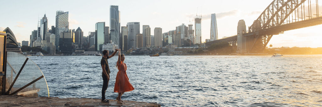 Ein Paar tanzt vor Sydneys Skyline.